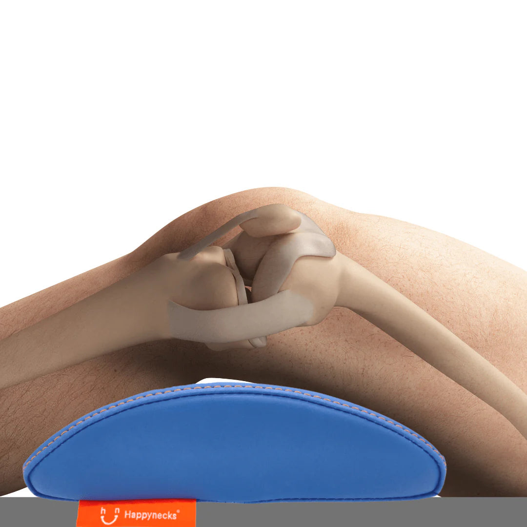 A close-up side view of a person resting their knees on the Happynecks® Pillow, which provides ergonomic support. The image highlights the skeletal structure of the knee joint, demonstrating how the pillow aligns and supports the knees for optimal comfort during a procedure.